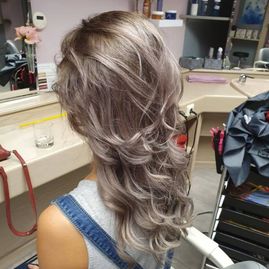 Ansicht von hinten: Haarschnitt mit Wellen bei einer Frau mit braunem Haar